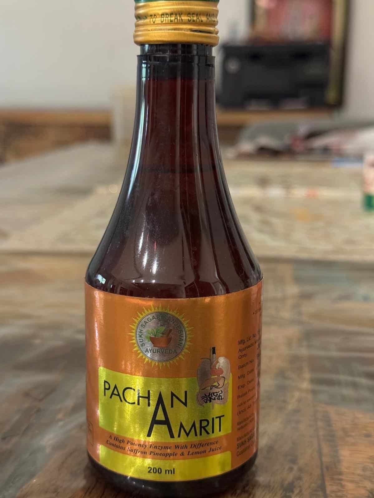 Panchan Amrit Syrup bottle with label on wooden surface.