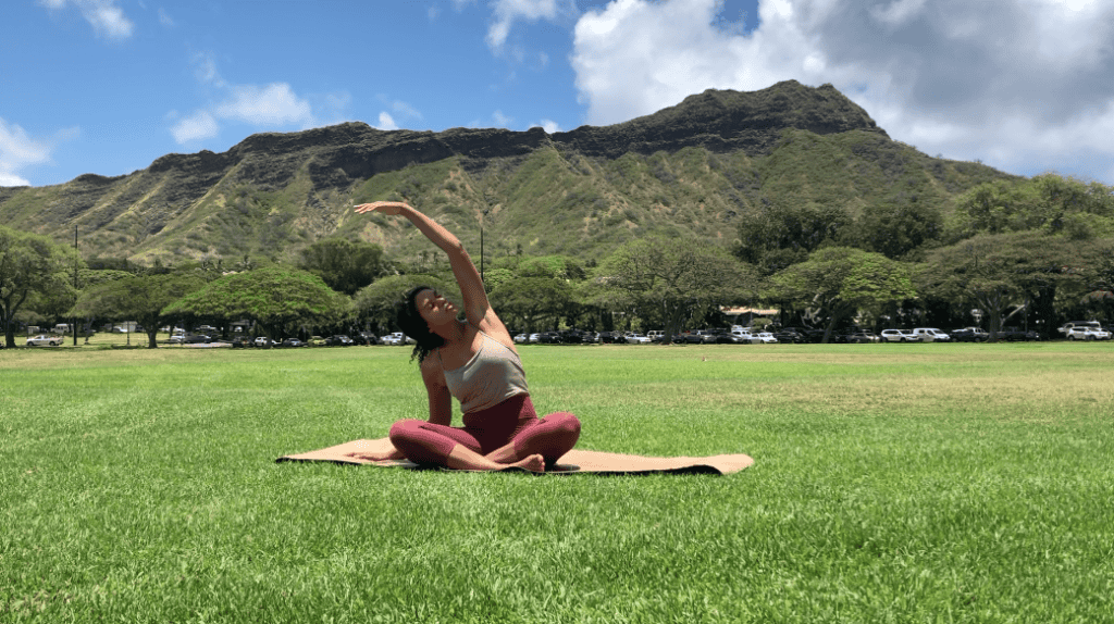 A black woman doing yoga as an online yoga class.