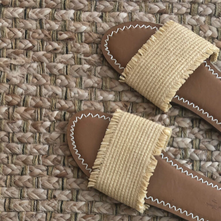 A thrifted pair of sandals on a jute rug.