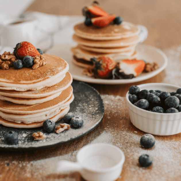 two stacks of pancakes with berries on top. The pancakes are protein pancakes.