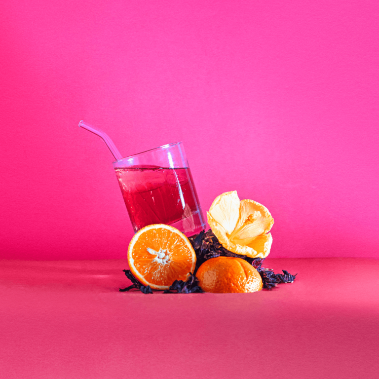 citrus fruit and a pink non alcoholic drink in front of a bright summery background
