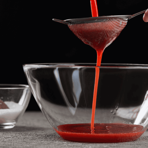 a strainer to make juice at home with no juicer. the juice is bright red.
