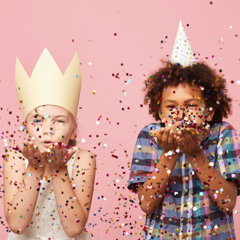 two kids blowing confetti and wearing diy party decorations that are low waste alternatives