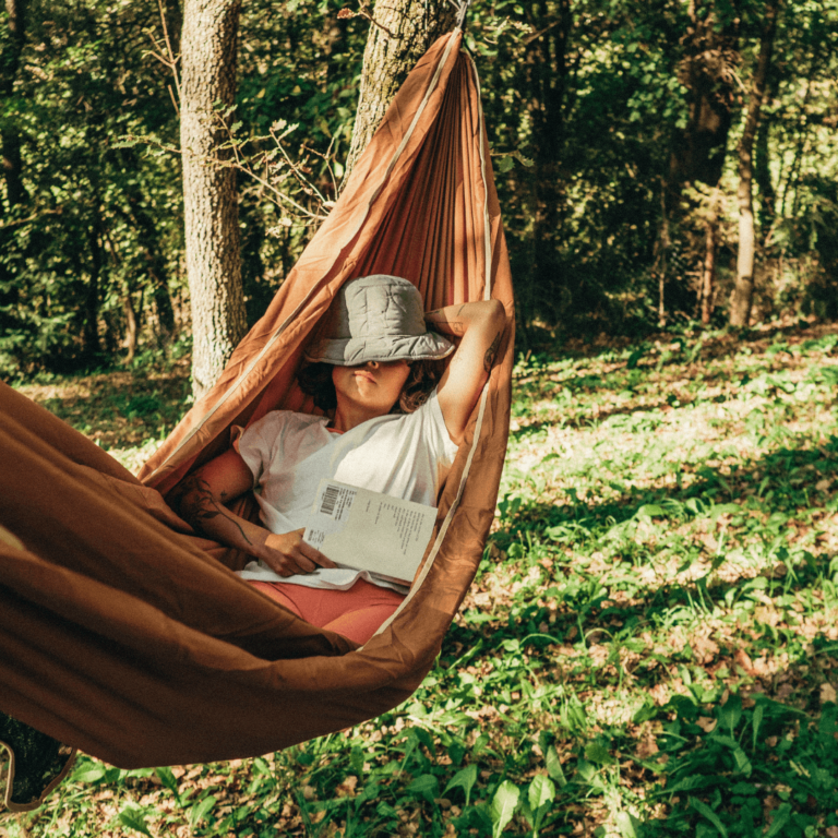 a person laying in a hammock outside