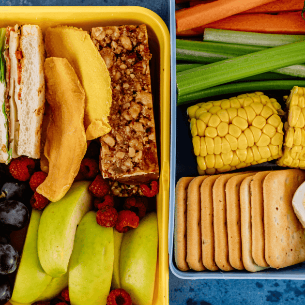 a healthy after school snack for teens which includes veggies, crackers, berries, a granola bar and a sand which