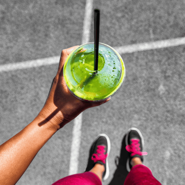 a person holding a green juice living their healthy lifestyle