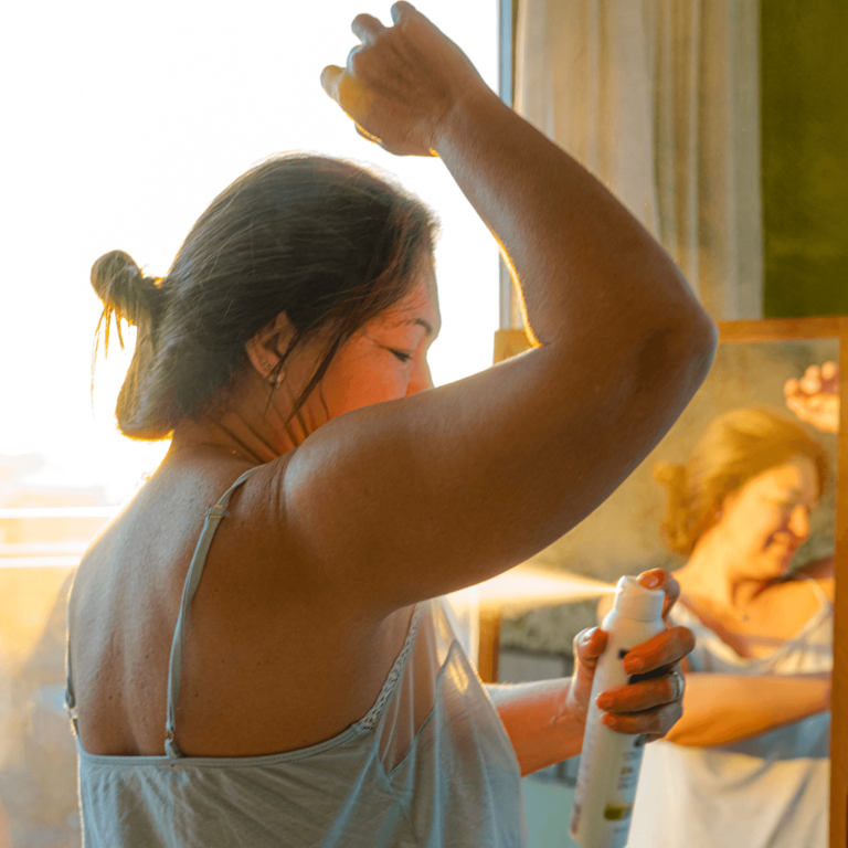 a woman putting on zero waste deodorant