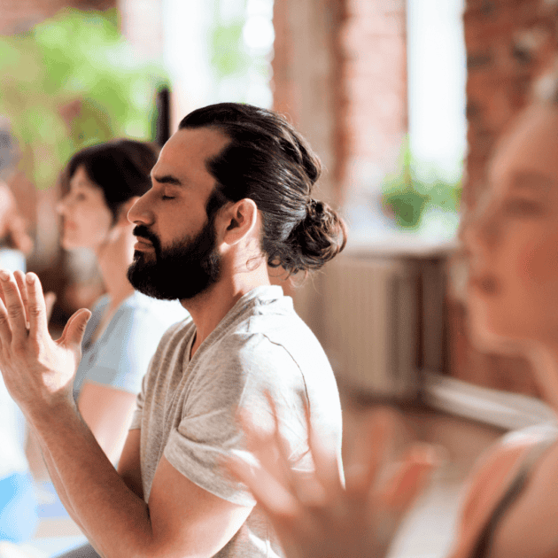 a man doing yoga as part of his self care routine
