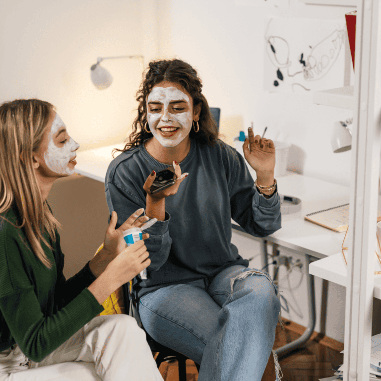 two college roommates hanging in their white minimalist dorm
