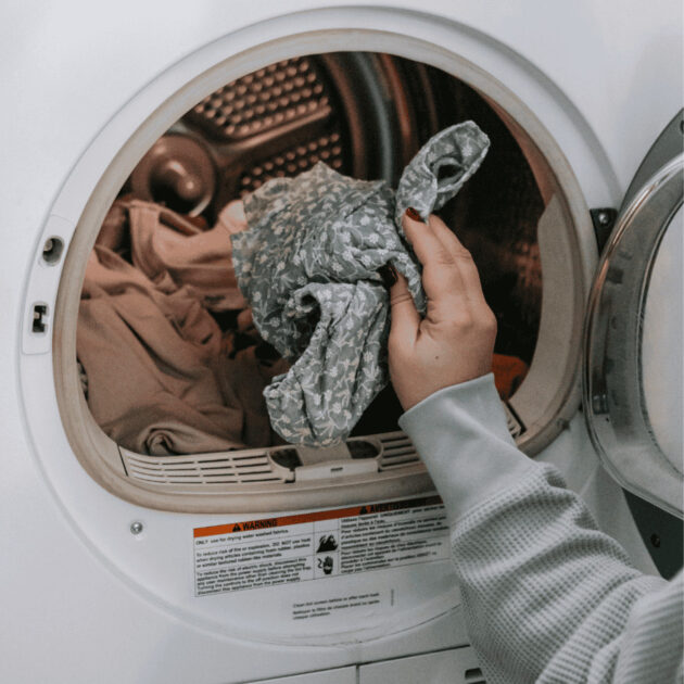 a woman washing beach towels in her laundry machine