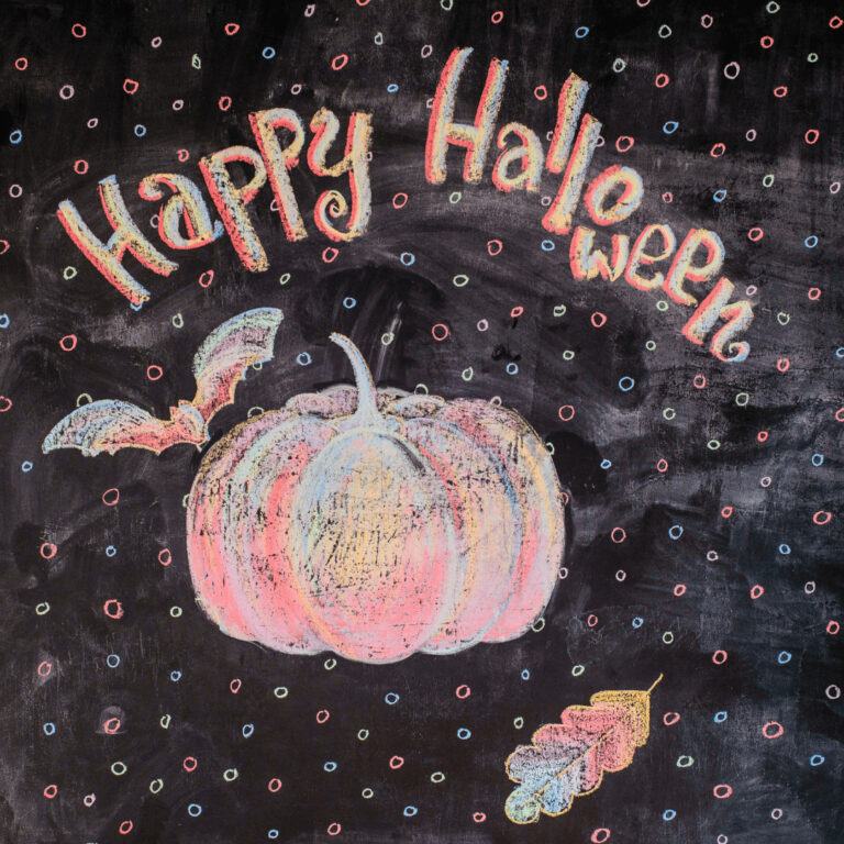 Pumpkin, bats and leaf and Happy Halloween greeting on chalkboard sign