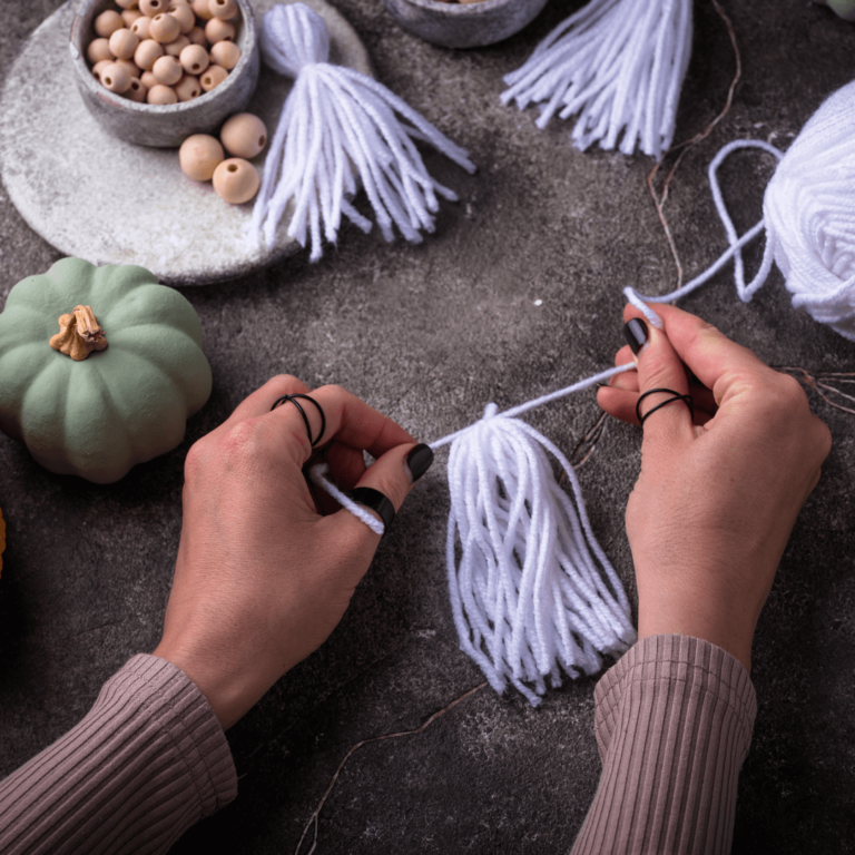 a person making a diy ghost garland for a Halloween party decoration