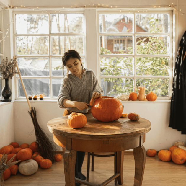 a woman carving a pumpkin
