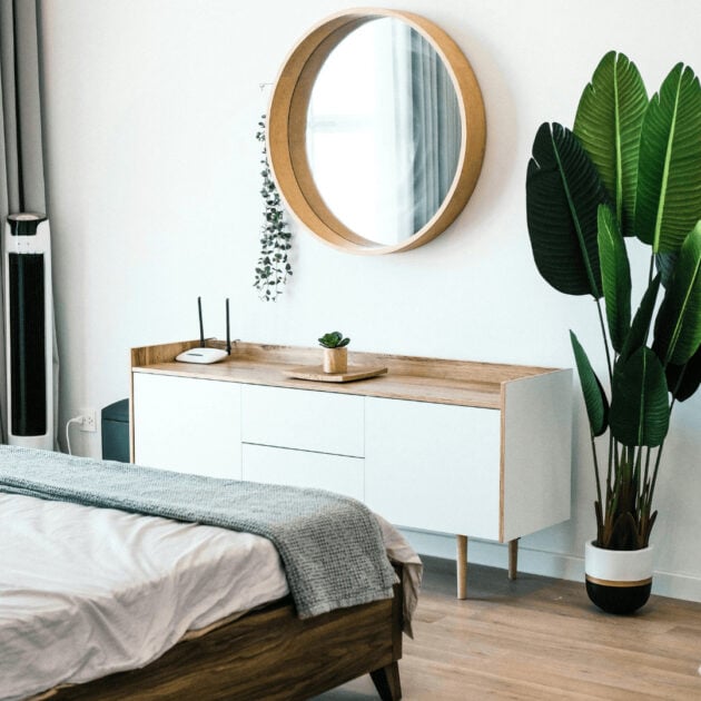 circular wooden mirror in bedroom