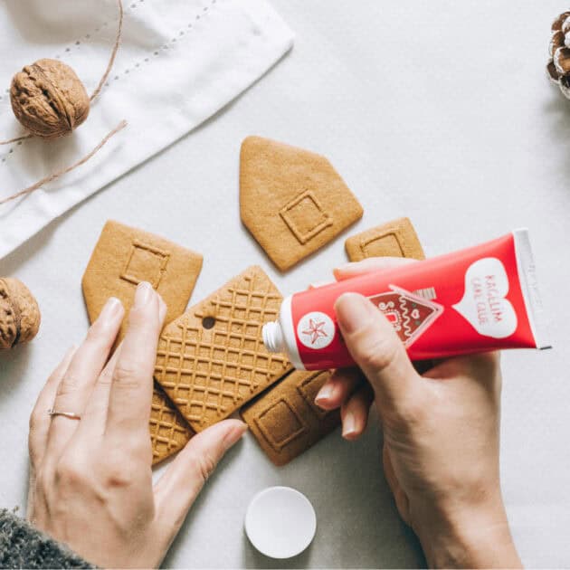 Icing being used to build a gingerbread house