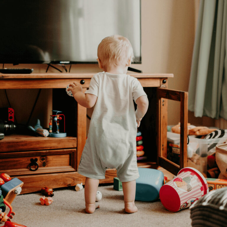 toy bins in a family room with a baby