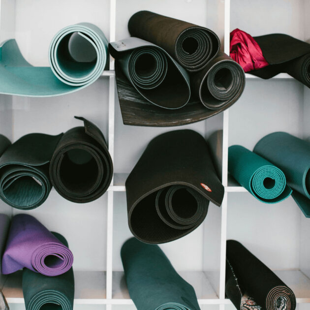 rolled yoga mats in a storage shelf