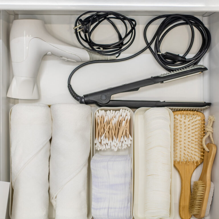 bathroom organizers with hair tools, toiletries, and towels