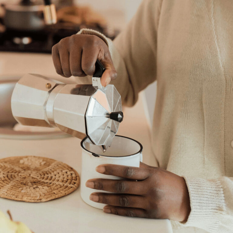 a woman making a coffee at a coffee station at home