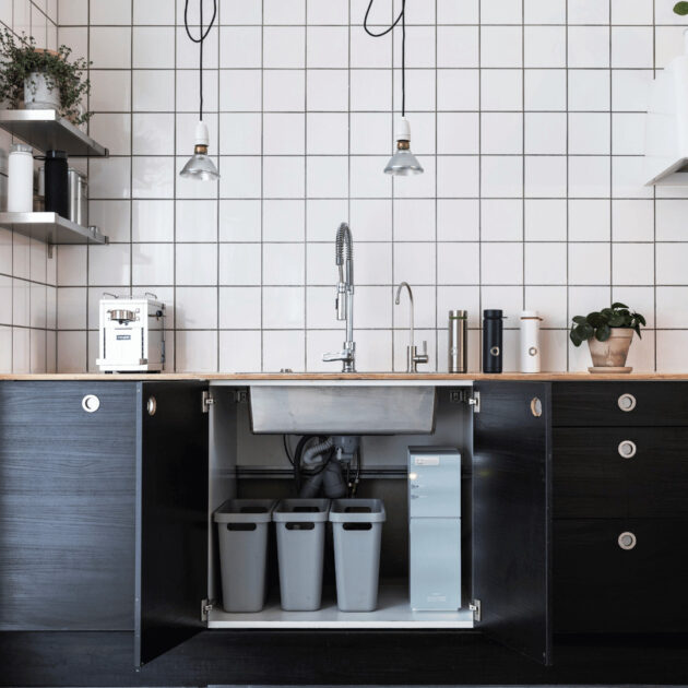 under a kitchen sink showing a garbage disposal