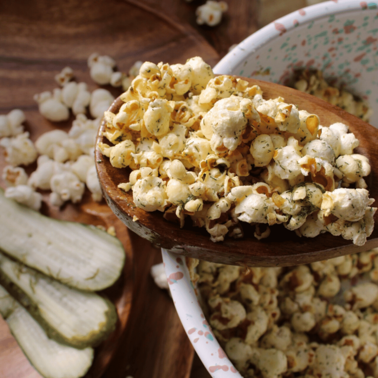 Dill pickle popcorn, pickles and bowls.