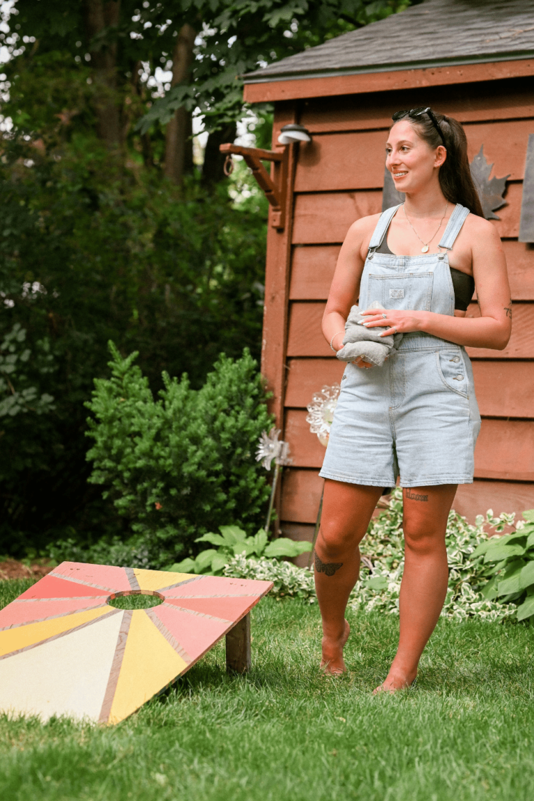 woman playing corn hole in her backyard