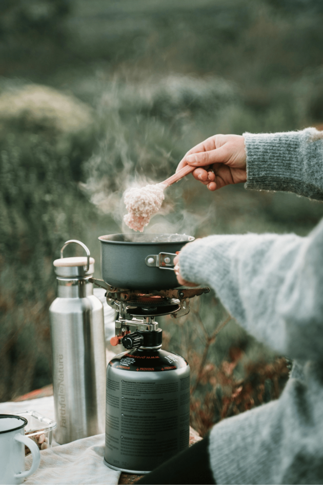 person making simple campsite breakfast