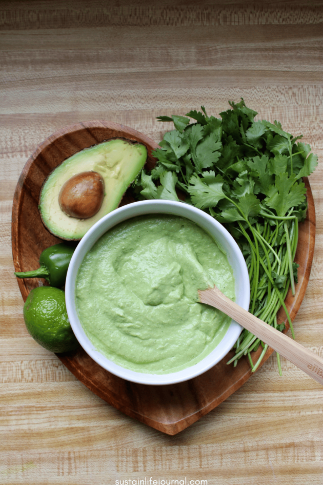 vegan avocado cilantro crema in a bowl and lime, avocado, jalapeño, and cilantro
