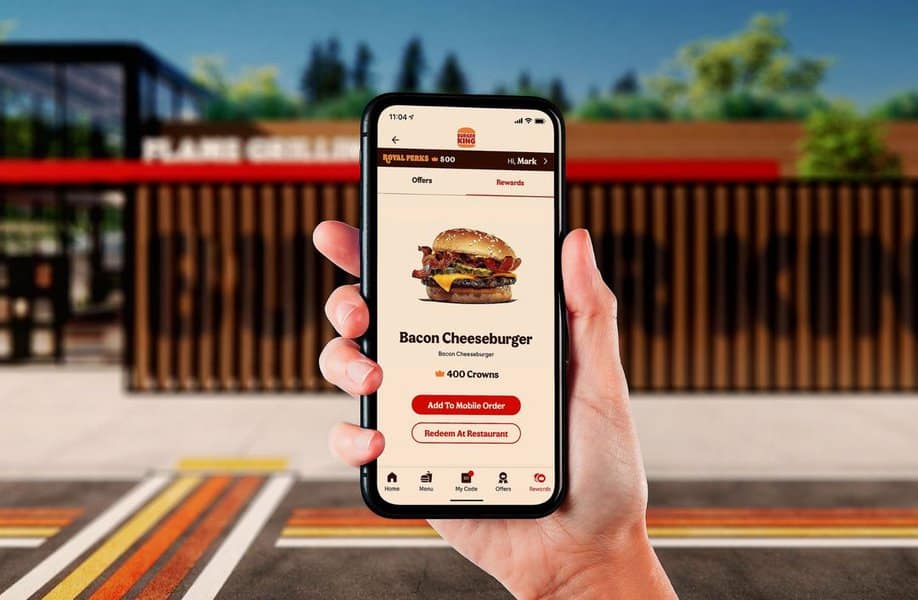 Hand holding phone with burger app display.