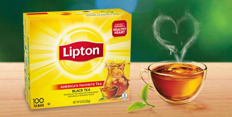 Lipton black tea box beside glass cup.