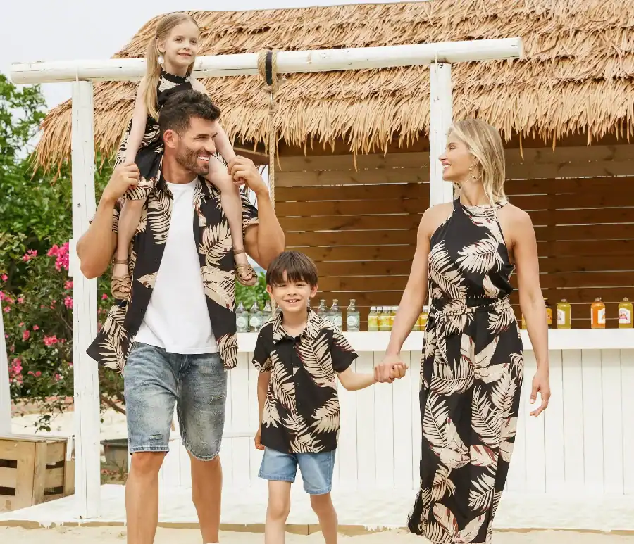 Family in matching tropical outfits on the beach