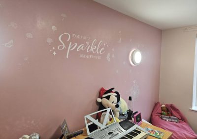 Child's room with pink wall, Minnie Mouse plush, and "Leave a Little Sparkle" wall decal.