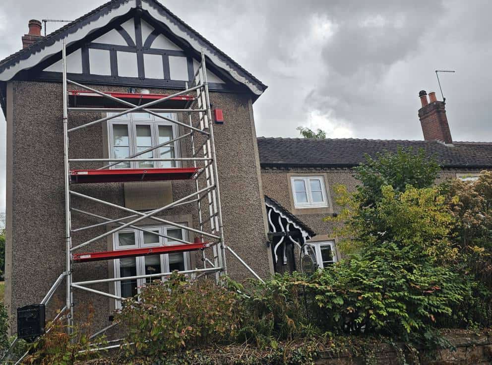 Painted house exterior with scaffolding for decorating work.