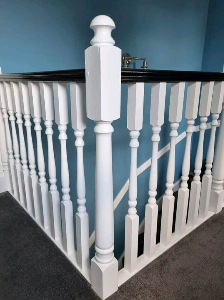 White painted stair railing with detailed balusters, professional decorating by SWS Painters & Decor.