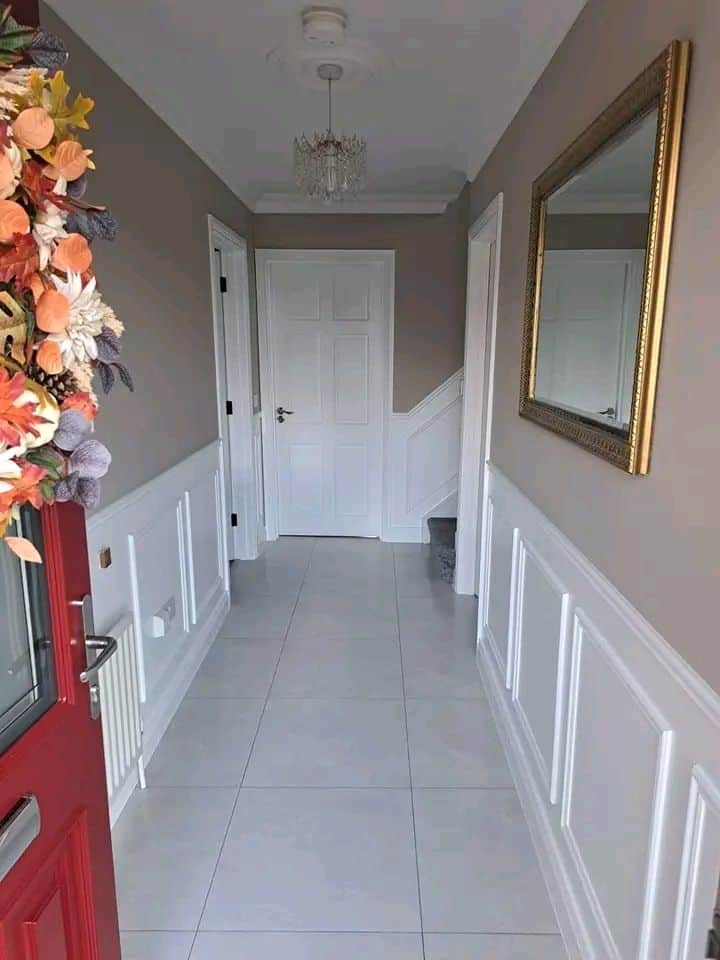 Modern painted hallway with wainscoting and mirror, professional decorators UK.