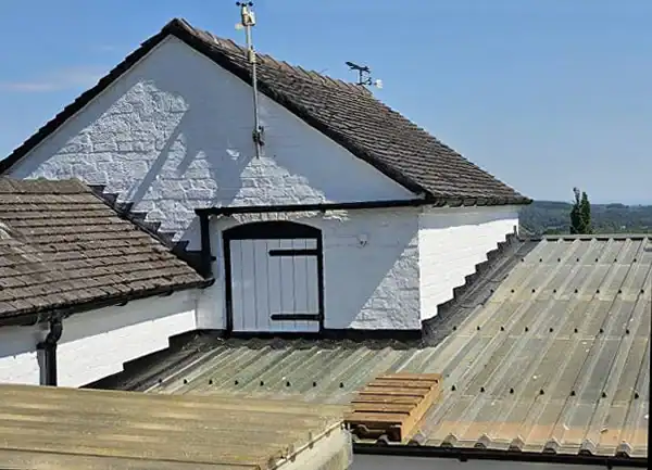 White-painted house with tiled roof and dormer window, exterior painting and decorating.