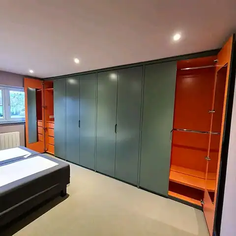 Custom painted green and orange wardrobes for bedroom storage solutions.