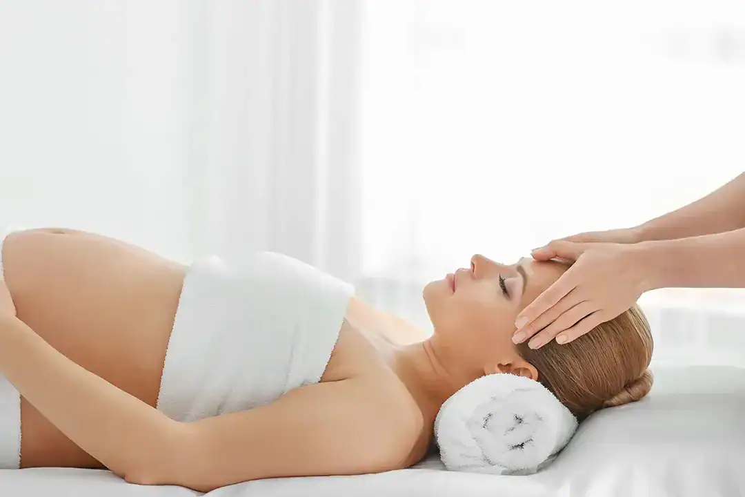Femeie gravidă primește masaj relaxant la TAKSU SPA.