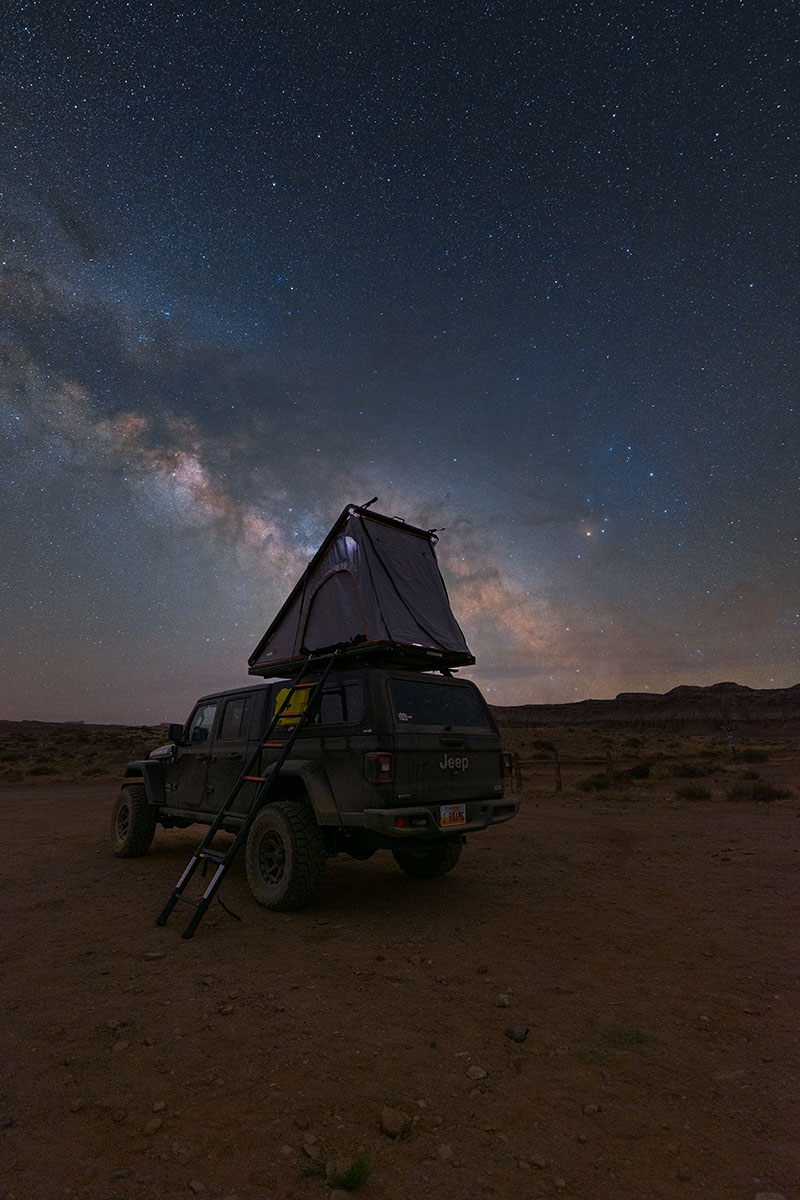 Escena de astrofotografía de un Jeep con tienda de campaña en el techo bajo un cielo lleno de estrellas y la Vía Láctea, demostrando consejos prácticos para la astrofotografía. @Jonny Hill