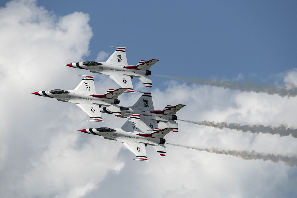 Four USAF Thunderbirds flying in tight formation during an airshow, captured with exceptional clarity using Tamron lenses for airshow photography.