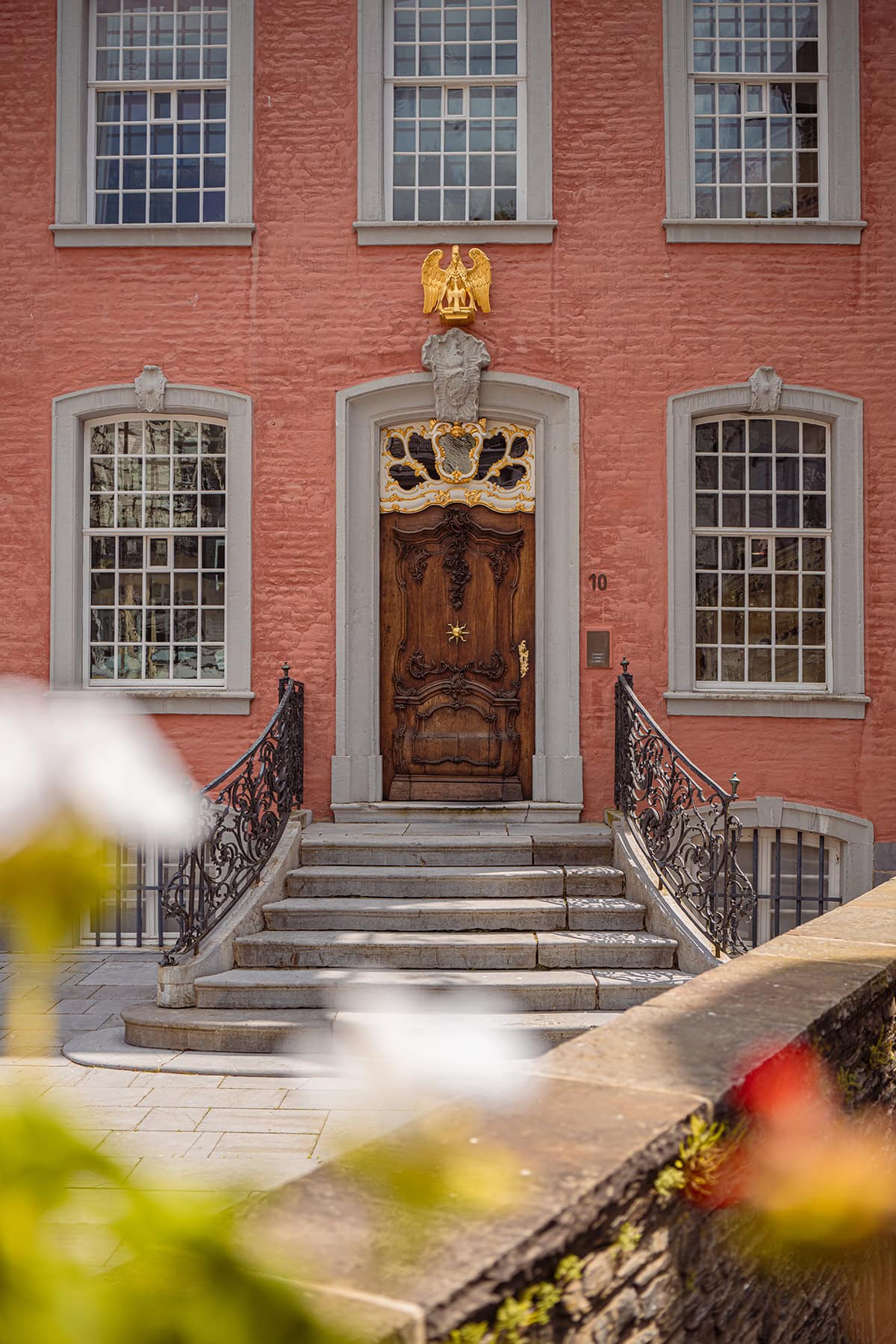 Una puerta de madera rica en detalles con adornos ornamentales y decoración de águila real, capturada utilizando trucos de fotografía local para resaltar la belleza arquitectónica.