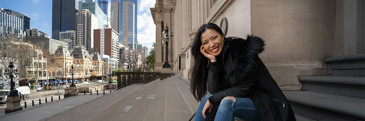 Mujer sentada en las escaleras de la ciudad en un retrato espontáneo y natural con un fondo urbano