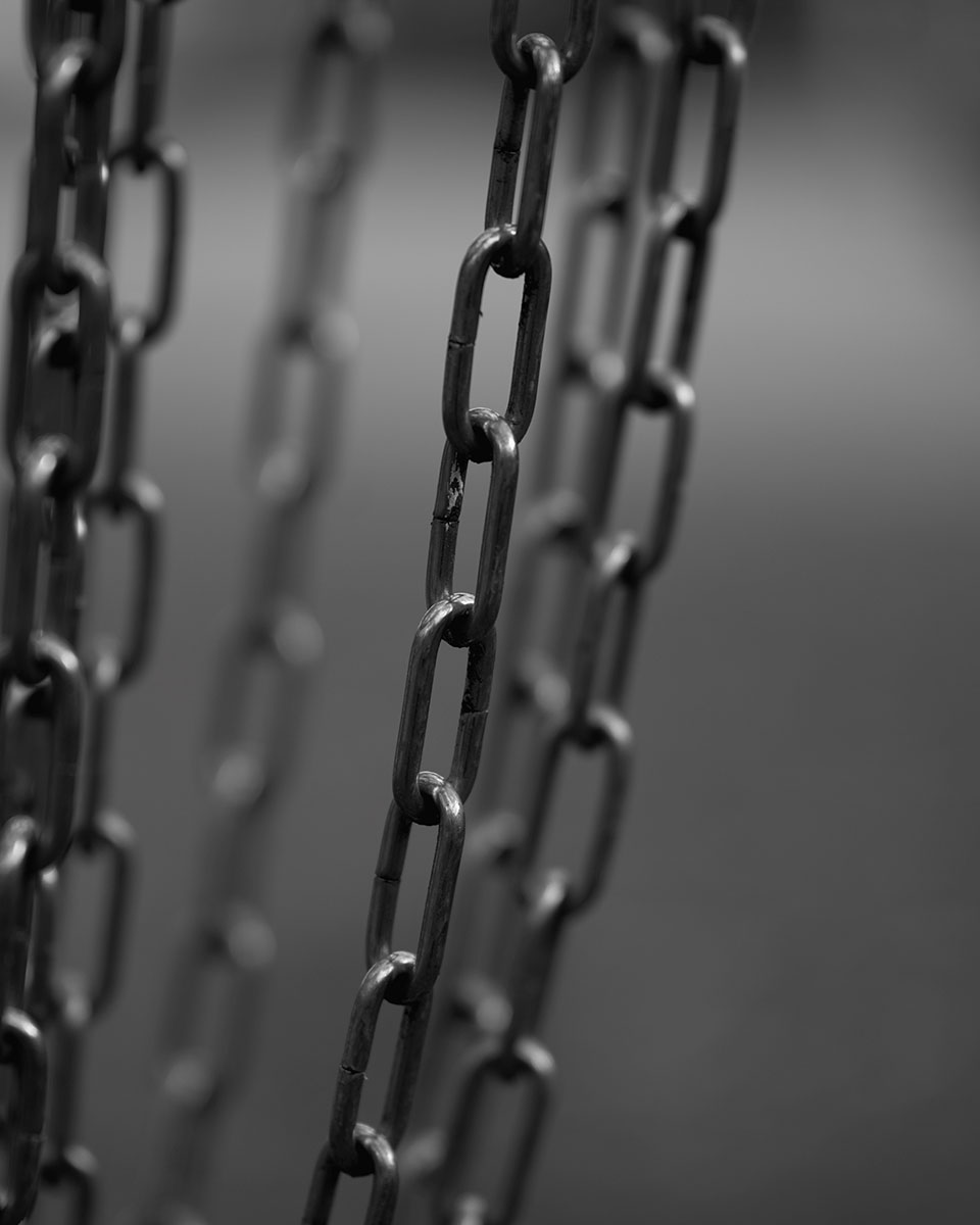 Foto de primer plano de cadenas de metal con poca profundidad de campo, que ilustra consejos de fotografía creativa de primer plano con la técnica de composición por capas.