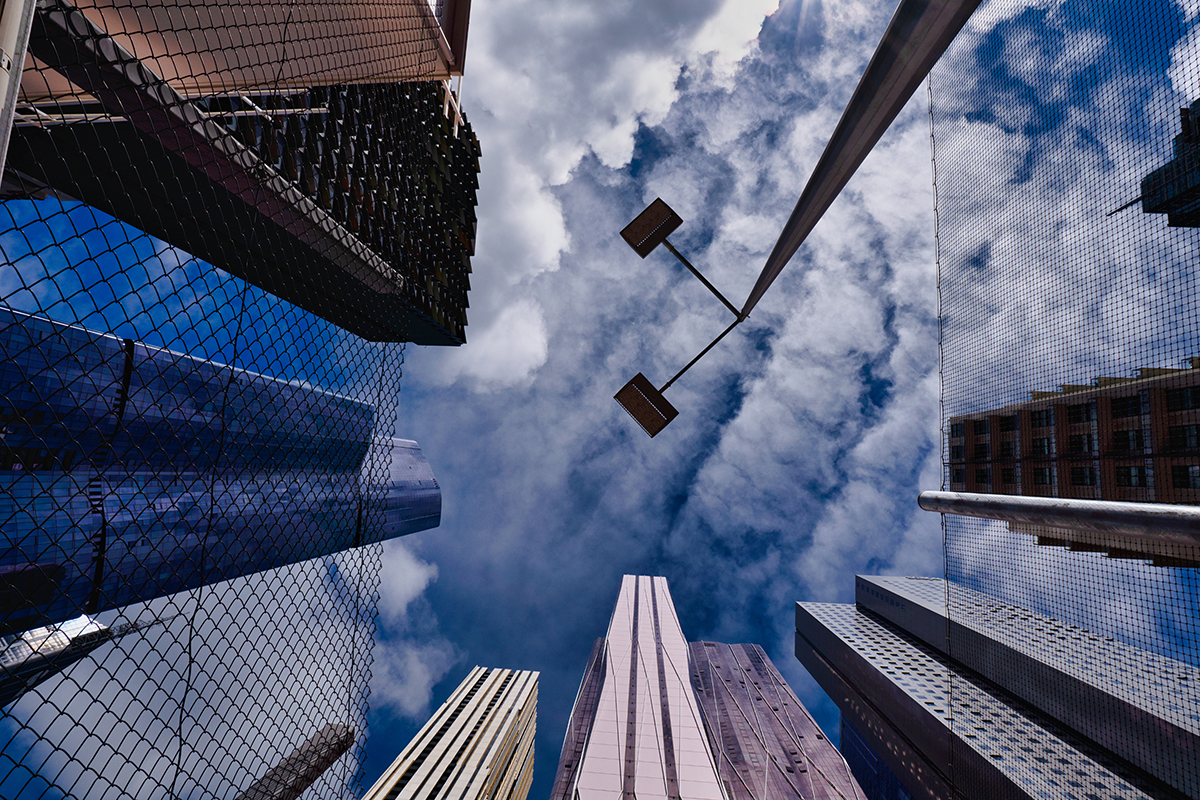 Looking up at modern skyscrapers and reflective surfaces in a city&mdash;an example of creative angles in urban travel photography. &copy;Glynn Lavender
