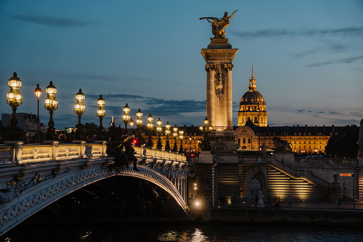 Vue du Pont Alexandre III de Paris à l'heure bleue avec des lampadaires lumineux - un moment parfait pour prendre de meilleures photos de voyage après le coucher du soleil.