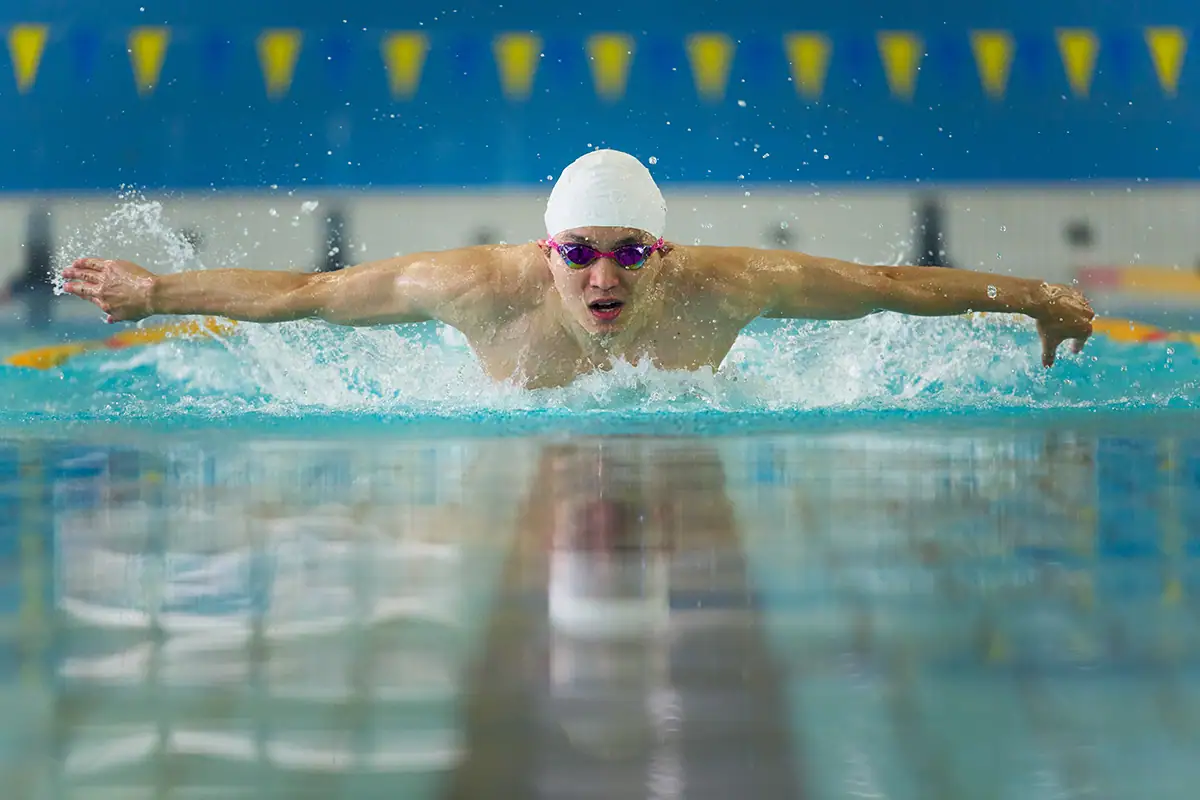Nadador en piscina cubierta fotografiado con uno de los mejores objetivos para fotografía deportiva, el Tamron 70-180mm G2.