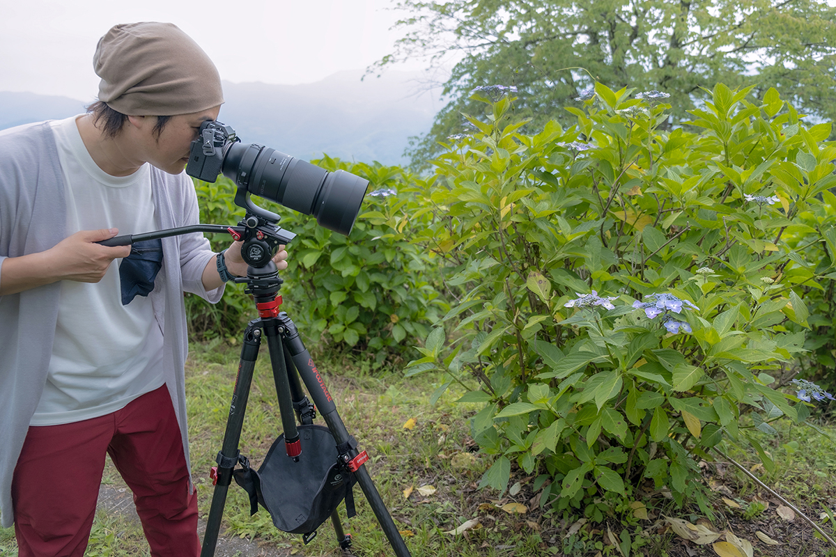 Photographe avec appareil photo sur trépied.