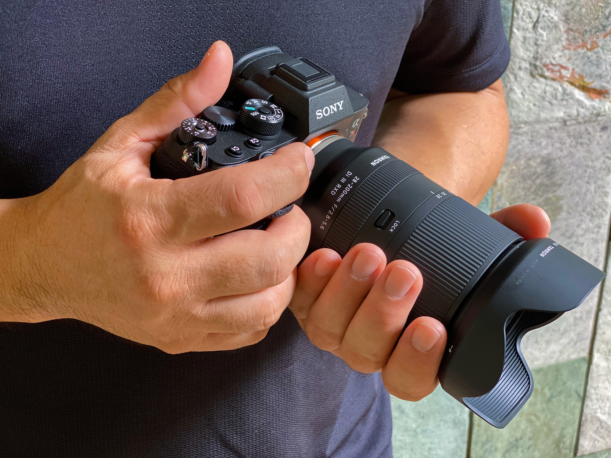 Alguien sujetando una cámara con el objetivo Tamron 28-200mm acoplado.
