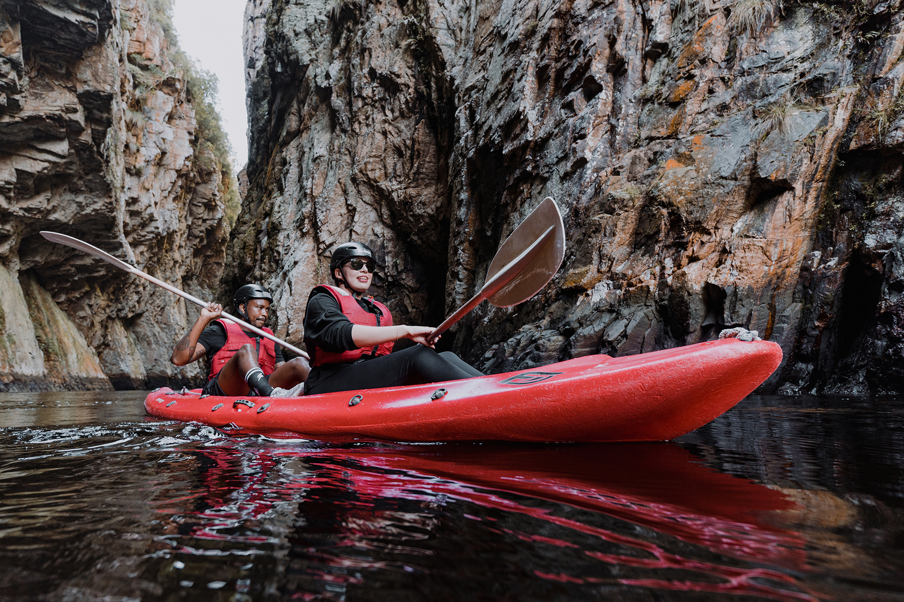 Dos personas en un kayak rojo.