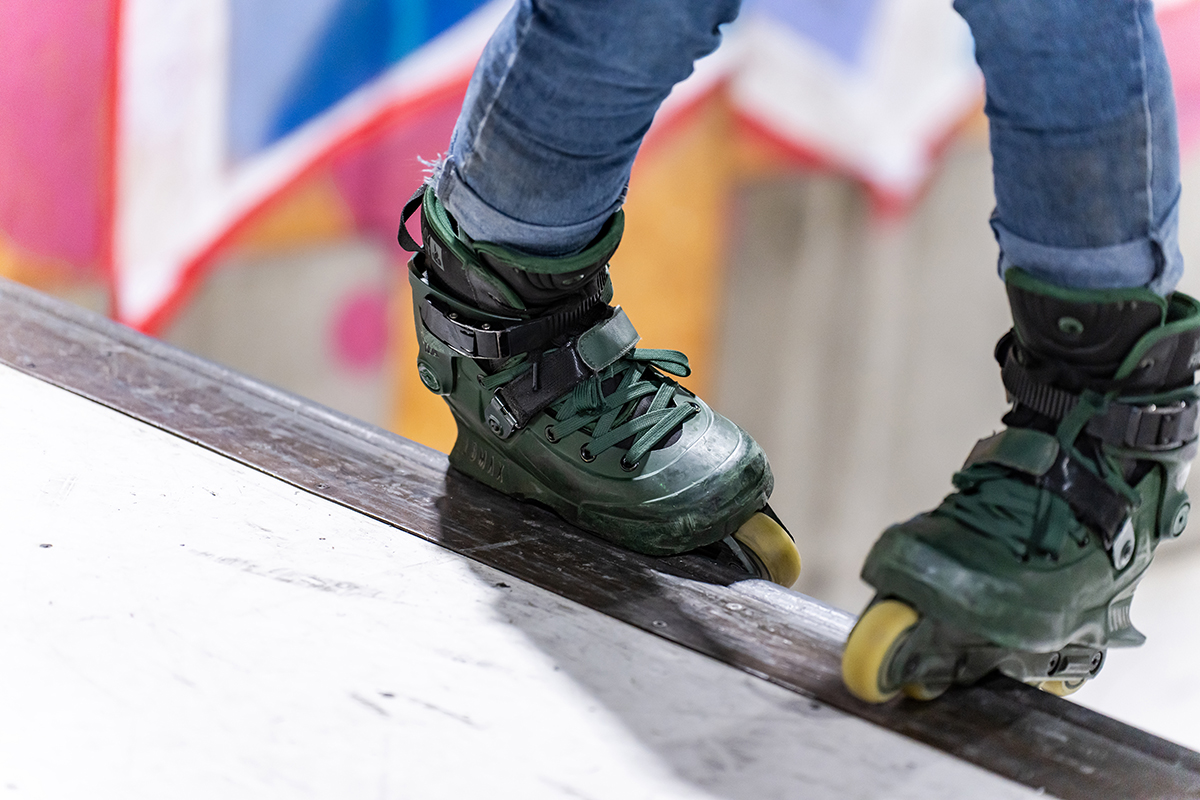 Primer plano de unos patines en línea balanceándose en el borde de una rampa, capturado por Noriyuki Watabe mientras fotografiaba deportes extremos con el TAMRON 35-150mm F2-2.8.